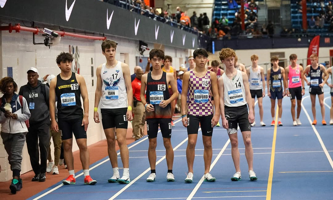 Athletes lined up on an indoor track before a race